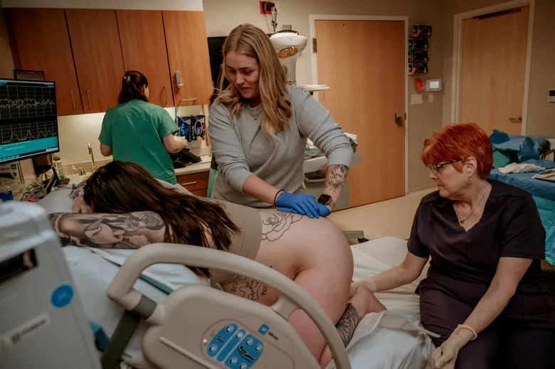 A doula in a hospital setting supporting a laboring client