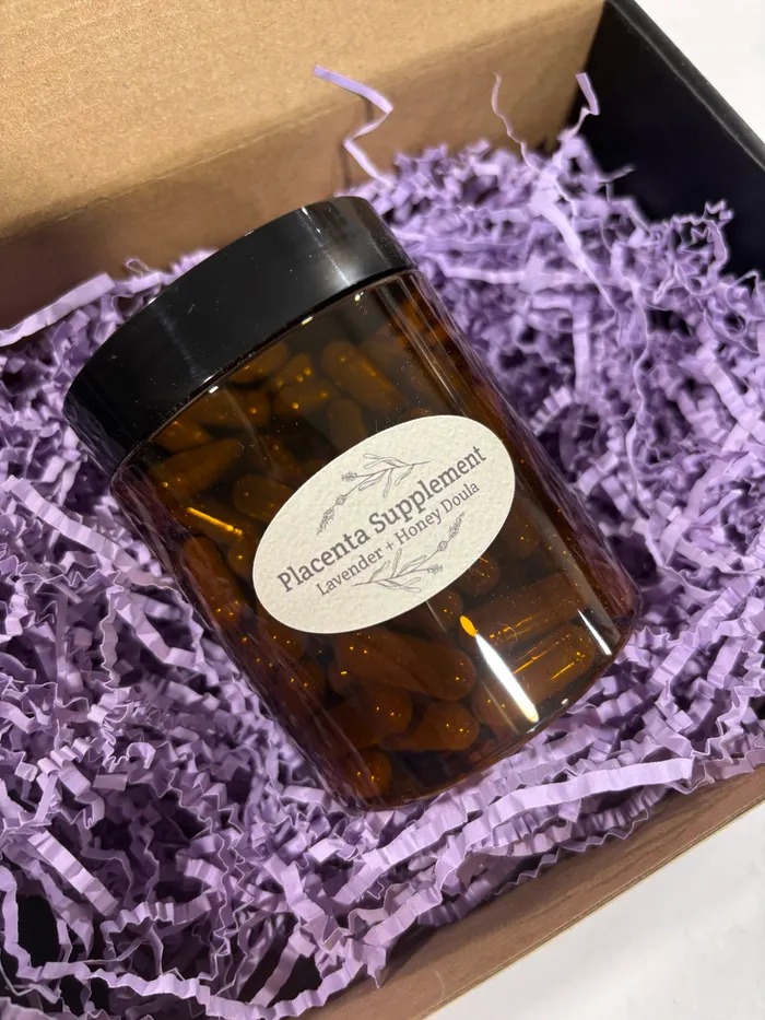 A jar of encapsulated placenta capsules, labeled Placenta Lavender + Honey Supplement