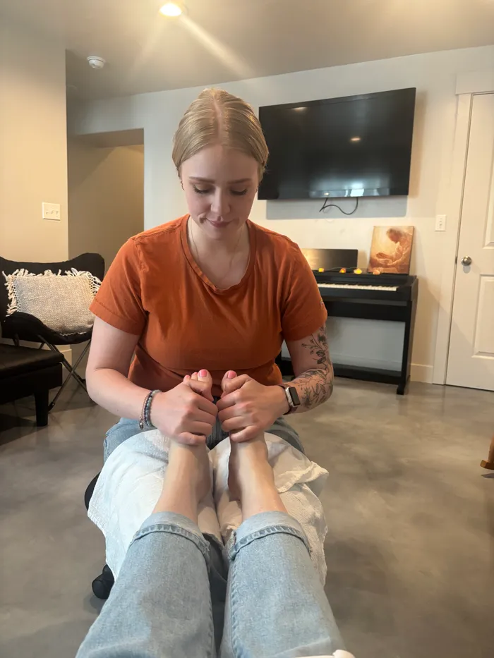 Jessica performing foot zone therapy for a client at home